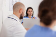 © DC Studio - Portrait of woman nurse analyzing healthcare expertise discussing medical examination with hospital teamwork sitting at desk in meeting conference room. Physician doctors discussing pills treatment