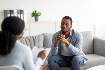 Psychological help service. Depressed male patient having psychotherapy session with counselor at mental health clinic