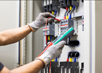 Wall Mural - Electrician engineer work tester measuring voltage and current of power electric line in electical cabinet control.	