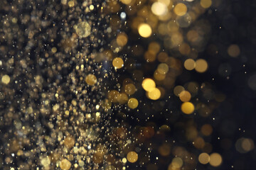 Wall Mural - blurred view of golden lights on black background. bokeh effect