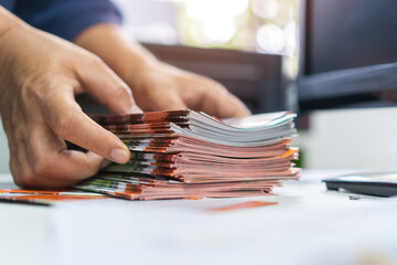 pile of presentation brochure document concept : businessman hands working in business documents on 