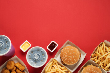 Different fast food on red background, flat lay. Space for text