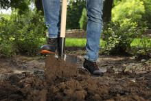 Worker Digging Soil With Shovel Outdoors, Closeup