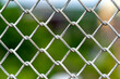 A close up picture of a rusty wire fence with colorful background