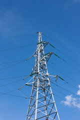 power line support against a background of blue sky and clouds