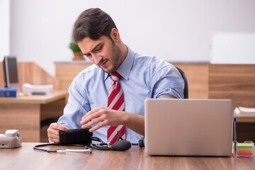 Young male employee suffering from hypertension at workplace