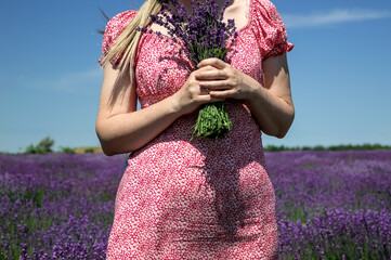 Woman in pink summer dress holding wild flowers. 