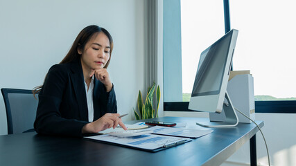 Businessman working in the office with laptop, tablet and graph data sheet to analyze company tax information.