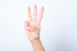© Roquillo - Woman's hand with pink manicure over isolated white background pointing up with fingers number three.