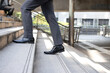 Business and grow up concept. Close up legs business man holding briefcase and walking up stairs going to work at morning in the city.