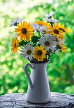 A Bouquet Of White And Yellow Daisies In A Vintage Ceramic Jug On The Windowsill Against The Background Of A Green Garden