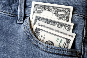 Money in jeans pocket - one, two and one hundred dollar bills. Close up.