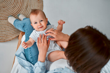 loving mom carying of her newborn baby at home.mom and baby boy playing in sunny bedroom. parent and