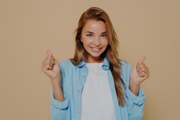 Overjoyed young european lady clenches fists with triumph