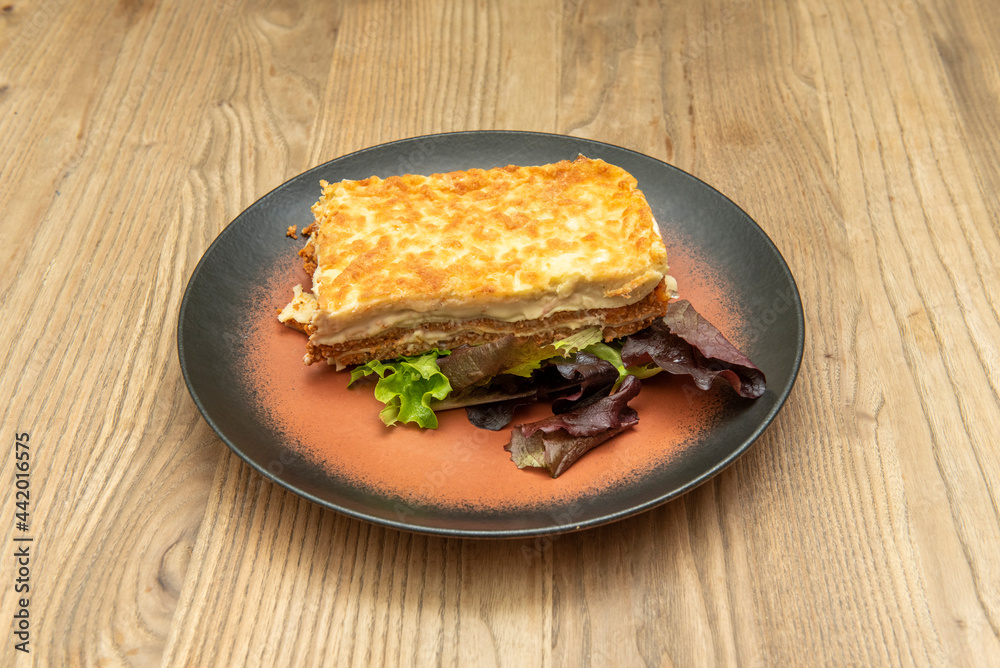 Rectangular portion of lasagna with several separate layers of meat and ...
