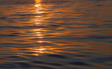 setting sun lights up the water in Lake Champlain
