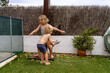 © ADDICTIVE STOCK - Adorable little siblings playing with water hose in backyard