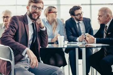 Wall Mural - smiling businessman sitting at an office Desk.