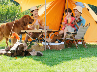 happy family of three and pet dog playing violin outdoors