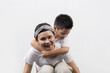 © Keopaserth - Young adult female cancer patient spending time with little son on gray background. Cancer and family support concept.