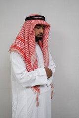 arabic man in turban praying while with two arms crossed on plain background