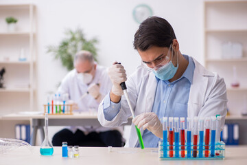 Two male chemists working at the lab during pandemic