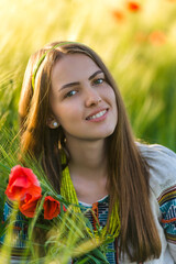 Wall Mural - Beautiful smiling slavonic girl in national embroidered costume on barley field