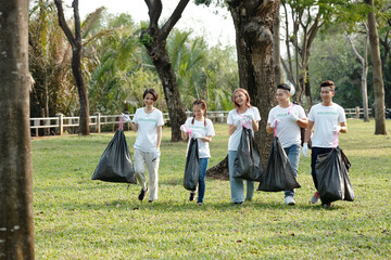 Poster - Positive young volunteers carrying bags of trash they picked on campus or in city park