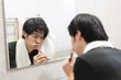 Adult asian man toothbrush in front of mirror toothache from decayed.