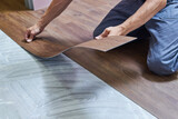 Fototapeta  - worker joining vinyl floor covering at home renovation