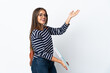 © luismolinero - Young student woman isolated on white background extending hands to the side for inviting to come