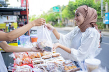A Beautiful Girl In A Veil Buys Takjil Food At A Roadside Stall