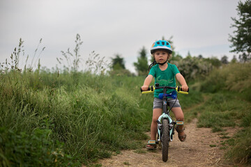 Poster - Cute little toddler child, riding a bike in the park