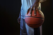 © Nomad_Soul - Basketball player holds ball, black background
