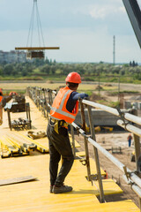 Worker with protective helmet at the construction site of a transport bridge