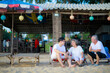 © sutthichai - Happy Asian family enjoy talking together on the sunbed on the beach side restaurant.