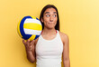 Young mixed race woman playing volleyball on the beach isolated on yellow background confused, feels doubtful and unsure.