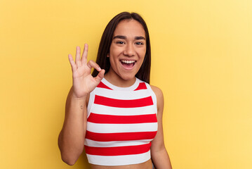 Wall Mural - Young mixed race woman isolated on yellow background cheerful and confident showing ok gesture.