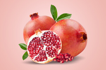 Wall Mural - A ripe pomegranate with seeds and leaves. Background with pomegranate fruit. Pomegranate fruit on a pink background. Horizontal.