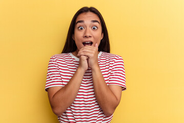 Wall Mural - Young mixed race woman isolated on yellow background praying for luck, amazed and opening mouth looking to front.