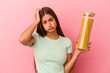 Young caucasian woman holding a pasta jar isolated on pink background being shocked, she has remembered important meeting.
