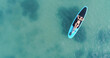  Attractive woman in bikini is sunbathing on a surfboard, aerial view