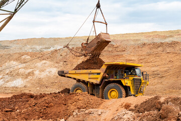 Wall Mural - large excavator loads rock with iron or bauxite mining