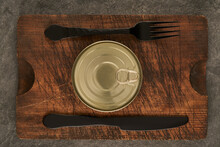 Cutting Board With Sealed Can And Fork On Wooden Table
