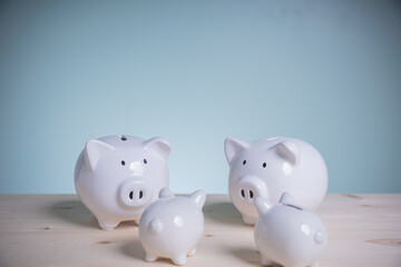 Family white piggy bank on old wood looking at green background. Father and mother little piggyback training save money for growth in the future. Concept family saving money for the future.