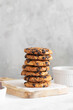 © zakiroff - American cookies with chocolate chunks on wooden plate with white napkin, lined with stack