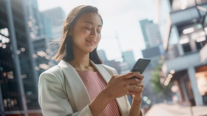 Sticker - Portrait of a Beautiful Japanese Female Wearing Smart Casual Clothes and Using Smartphone on the Urban Street. Manager in Big City Connecting with People Online, Messaging and Browsing Internet.