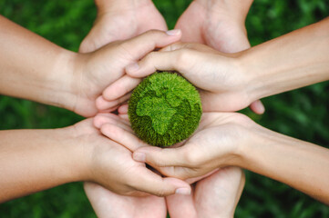 Wall Mural - top view of teamwork hands holding the earth on a green background. protect nature. Save Earth. concept of the environment World Earth Day. ecology and environment sustainable concept.