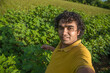 © Dip Photography - Young man farmer in a cotton farm taking selfie using a smartphone or camera.