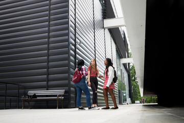 Three students hanging out around their campus